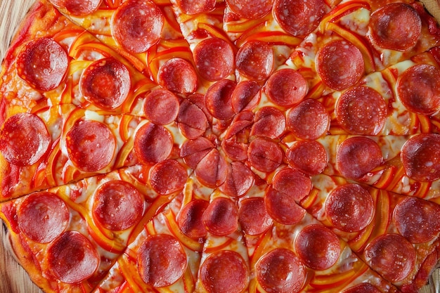 Photo pepperoni pizza on wooden boards with melted cheese and slices