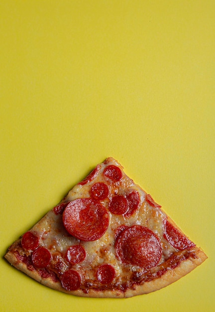 Pepperoni pizza on yellow color background