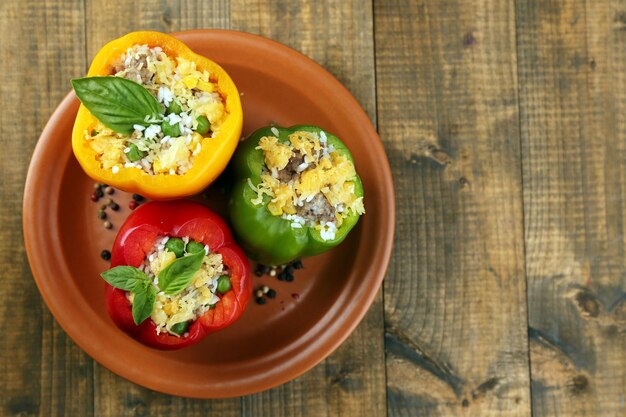 Peppers prepared for cooking stuffed paprika with meat and rice on plate on wooden background