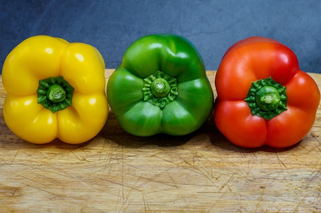 Peppers in three colours on a kitchen breadboard