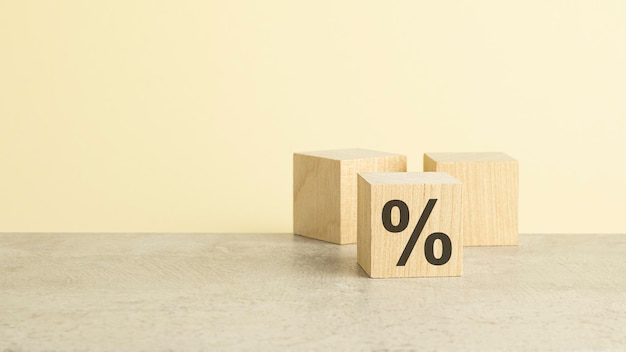 Percent sign on wooden cube with copy space concept of sale and discount yellow background