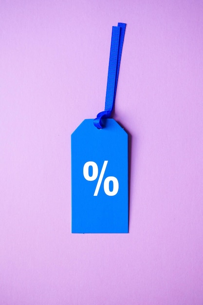 percent symbol on the blue price tag, pink background