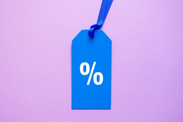 percent symbol on the blue price tag, pink background