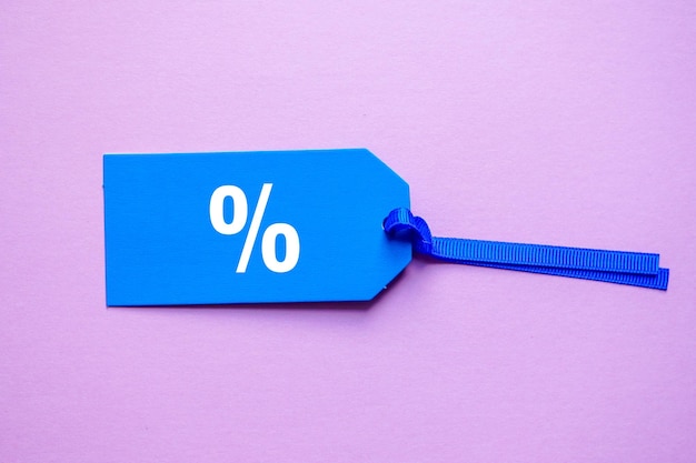 percent symbol on the blue price tag, pink background