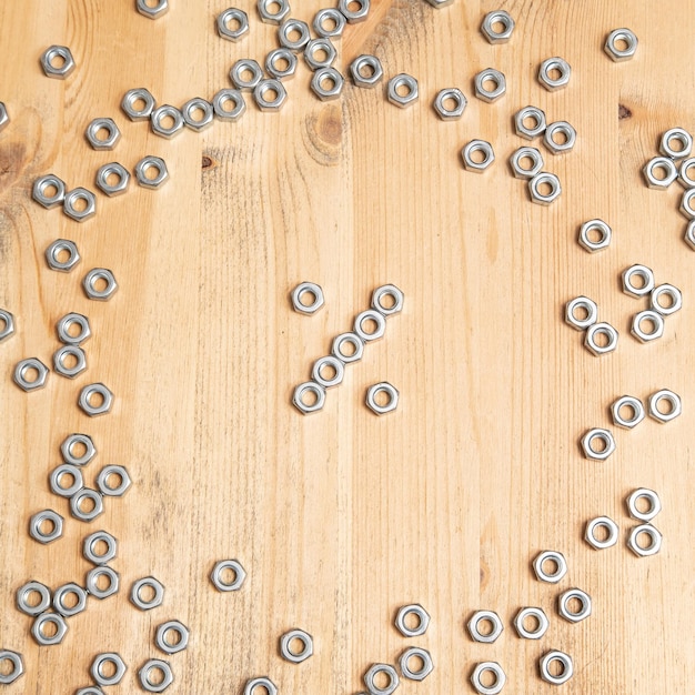 Percentage sign made from metal nuts on a wooden table