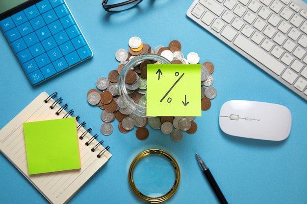 Percentage symbol on sticky note with a coins and calculator