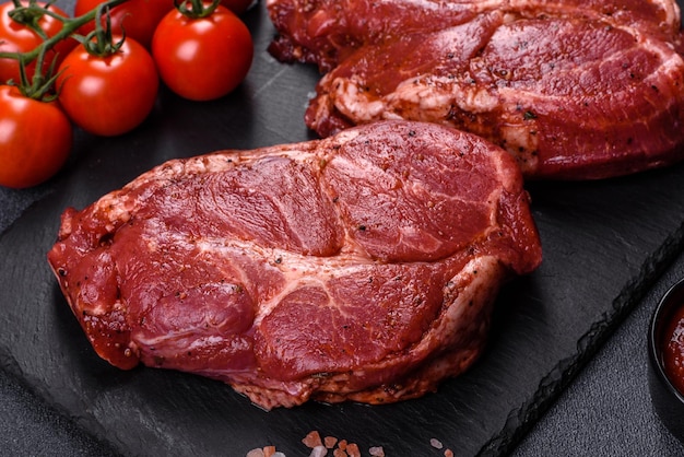 Perfect raw rib eye beef steak on black wooden background, close-up