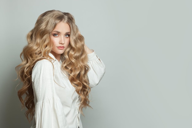 Photo perfect young woman with long blonde healthy curly hairdo on white background