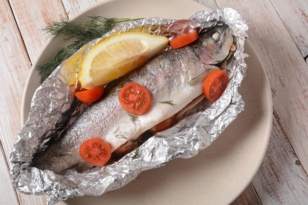 Perfectly baked oven trout with lemon and dill with cherry tomatoes olive oil lemon juice in foil