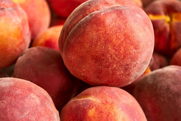 A perfectly ripe orange peach lying on a pile of other fruits summer fruit harvest is a good plan