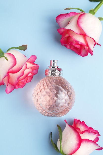 Perfume bottle and rose flowers Concept of expensive perfume and cosmetics Floral fragrance for women Perfume spray