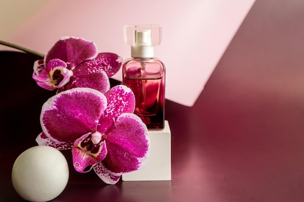 Perfume bottle with orhid flowers. Perfumery cosmetics toilet water fragrance collection. High quality photo