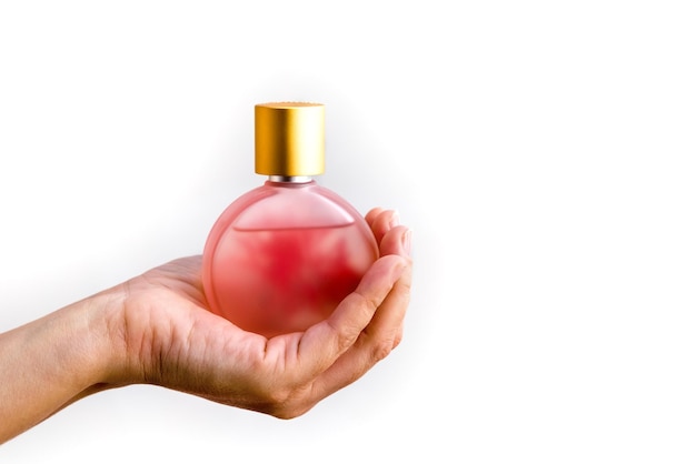 Perfume bottle in a woman's hand on a white background