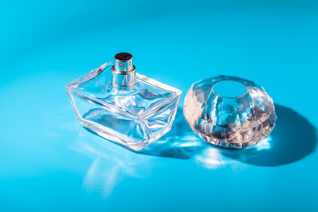 Perfume glass bottle on light blue. Eau de toilette