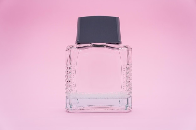 Perfume glass bottle. Perfume bottle with blank label on pink background.