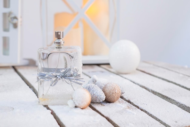 perfume on a snowy wooden with balloons cones against the background of blurry lantern lights 