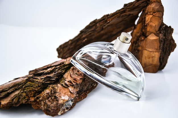 Perfume in tree bark with drops of water.