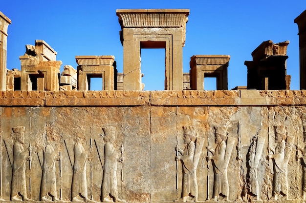 Persepolis is the capital of the ancient Achaemenid kingdom sight of Iran Ancient Persia Basrelief carved on the walls of old buildings against the blue sky