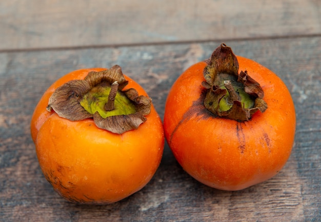 Persimmon fruit on an old wooden surface,