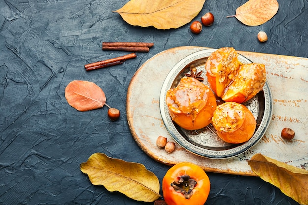 Persimmon stuffed with granola and caramel sauce.Baked persimmon.