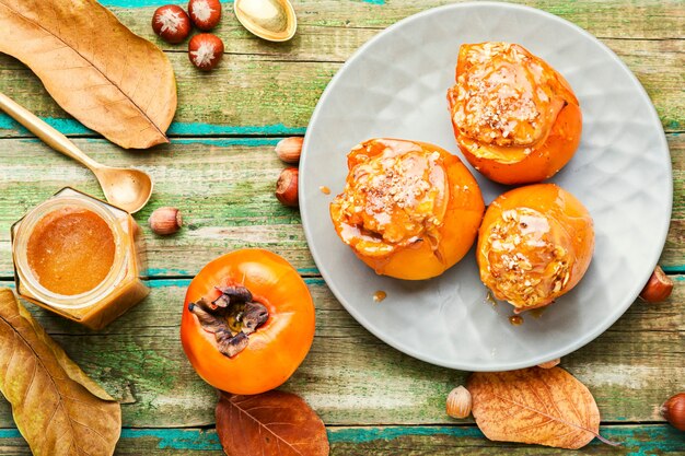 Persimmon stuffed with oatmeal with caramel sauce.Baked persimmon.Autumn dessert.