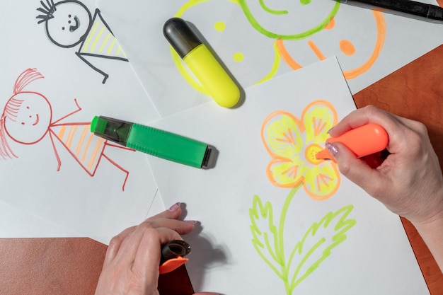 Photo a person drawing a flower on a piece of paper with a marker on it.