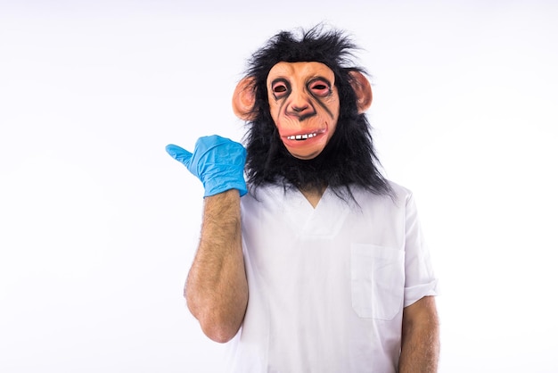 Person dressed in overalls with a mask wearing a medical nurse outfit pointing a finger to the side on white background Monkeypox pandemic virus epidemic Nigeria and smallpox concept