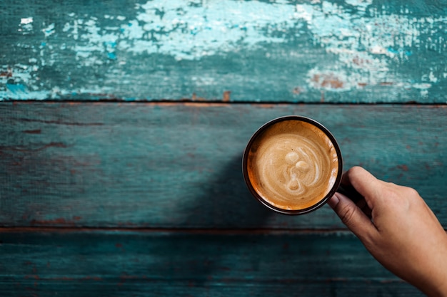 Person drinking coffee on old blue table