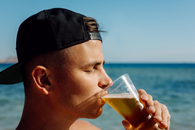 Person drinking a glass of beer at sea portrait man drinking beer in summer