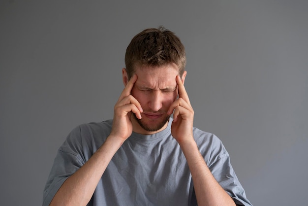 A person feeling headache and touching head with his hand