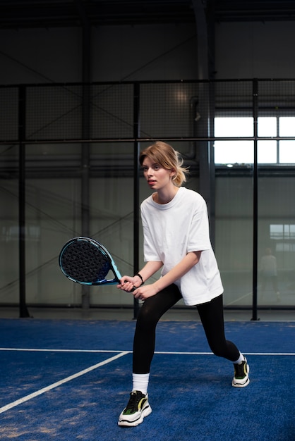 Person getting ready to play paddle tennis inside