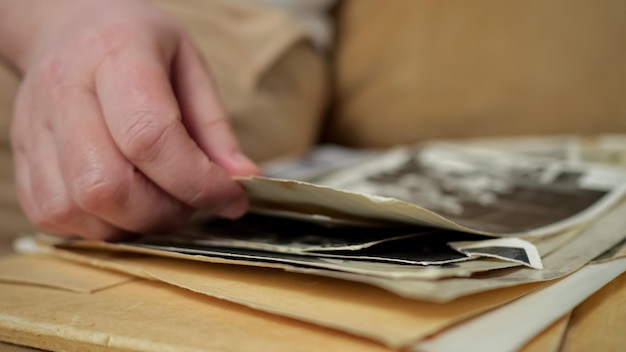 Person grabs and examines carefully old photos from album