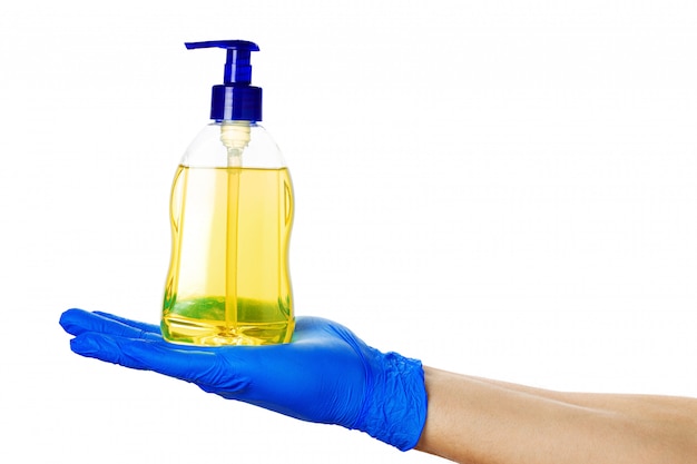 Person hand in blue glove hold soap bottle isolated. Close up.