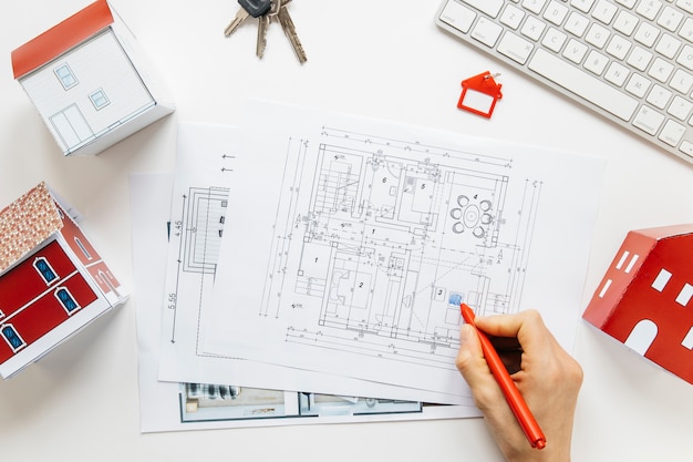 A person hand's writing one blueprint at keychain on white backdrop