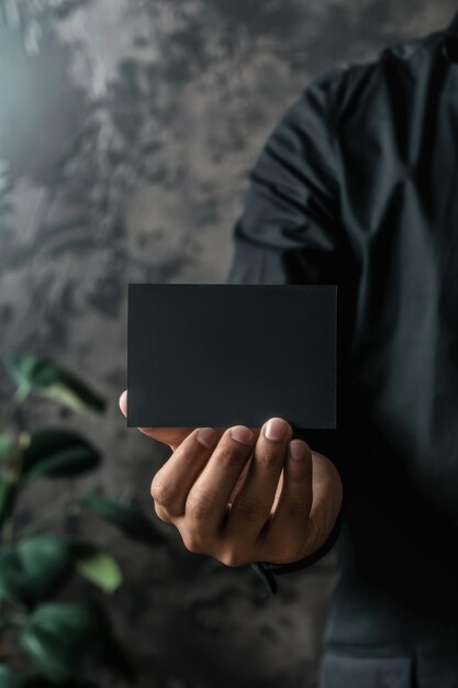 Photo person holding a black business card mockup with ample copy space perfect for showcasing branding