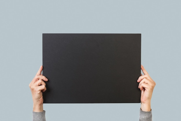 A person holding a blackboard with the word art on it.