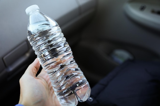 A person holding a bottle of water in their hand