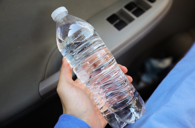 A person holding a bottle of water in their hand