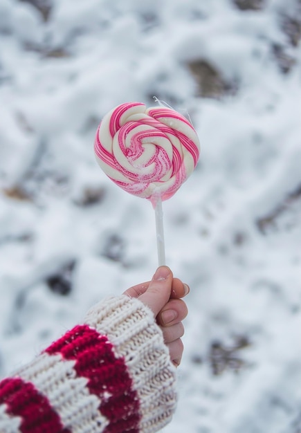 a person holding a candy cane with a white and red candy cane