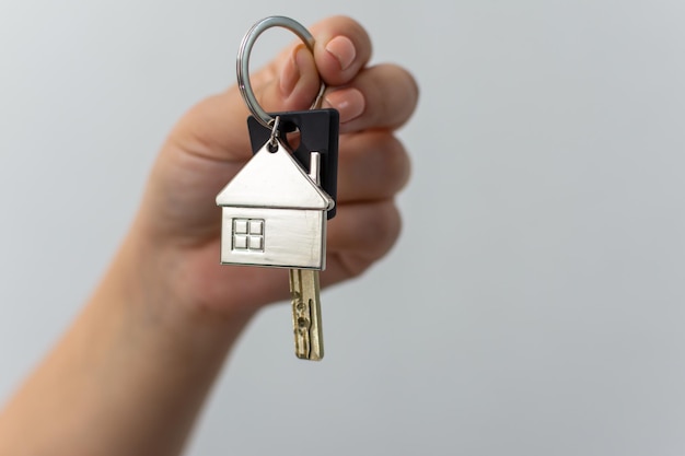 Person holding key with house keychain ready to unlock car alarm