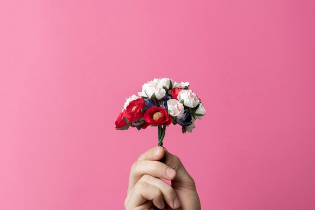 Person holding a mini flowers bouquet happy holidays creative concept