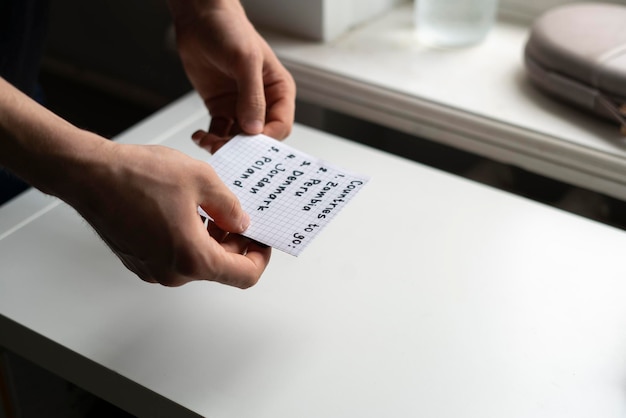 A person holding a paper note with countries to visit list