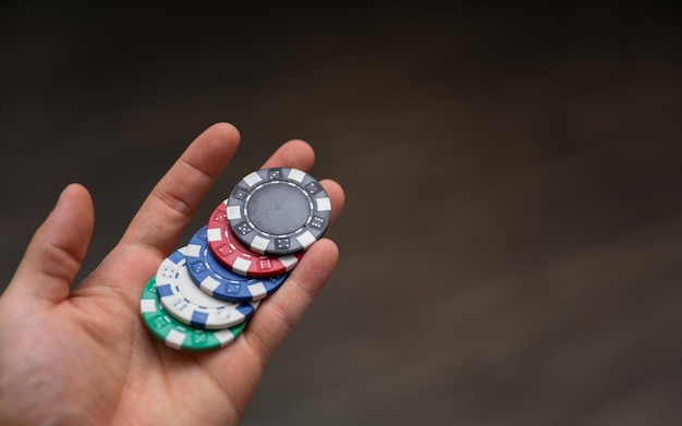 a person holding a stack of poker chips in their hand.