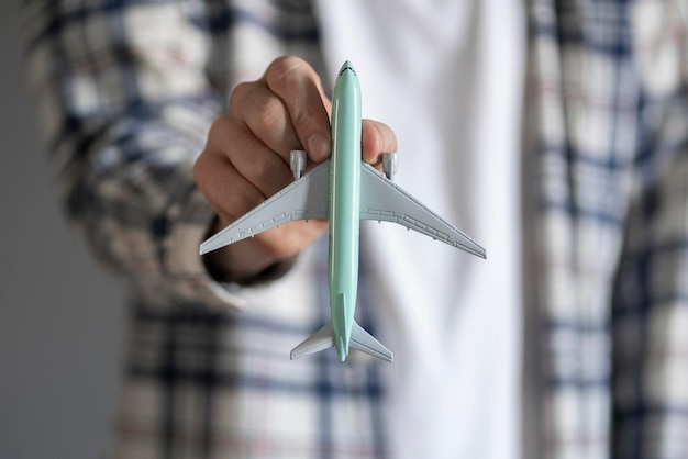 A person holding a toy airplane as the symbol of travel and transportation