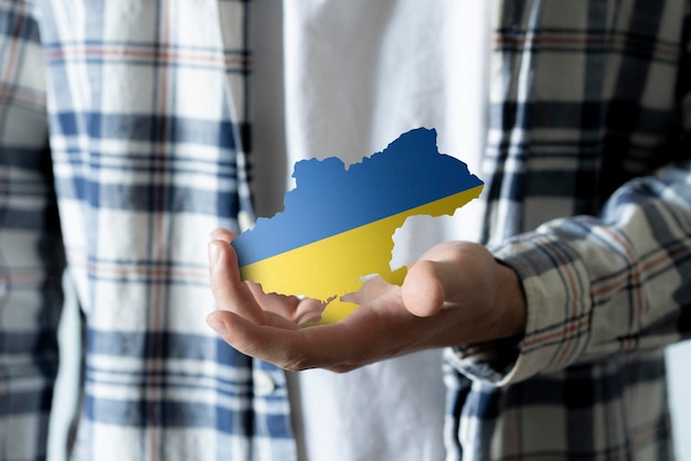 A person holding ukranian map in blue and yellow colors