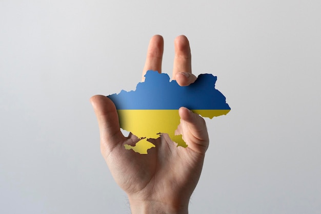 A person holding ukranian map in blue and yellow colors