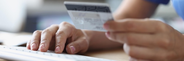 Person holds credit bank card and computer keyboard online payments and online money transfer