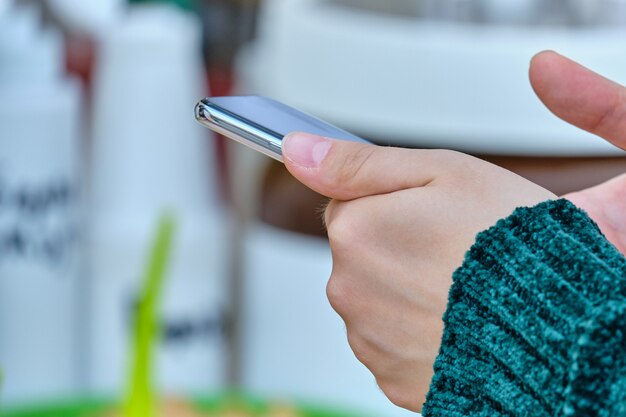 Photo person holds a smartphone and uses it.