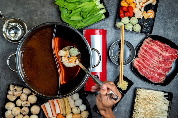 Photo a person is eating food from a bowl with chopsticks