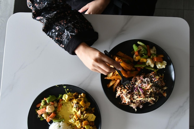 Photo a person is eating a meal with a fork and knife.